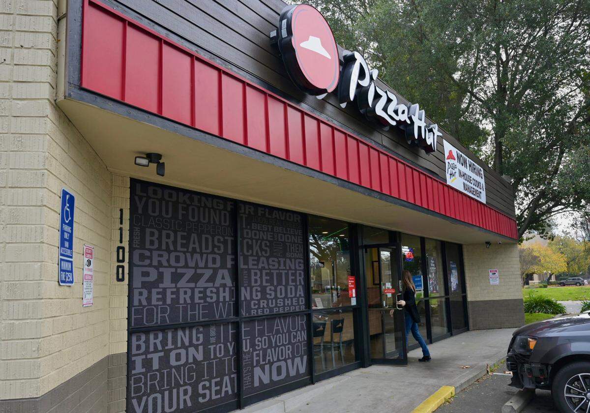 Un cliente entra en el Pizza Hut en 1100 Fulton Ave. en Arden Arcade, el miércoles, 27 de diciembre de 2023. El propietario de la franquicia del Condado de Sacramento está despidiendo a los conductores de entrega para evitar pagar la tarifa de $20 por hora requerida por una nueva ley estatal para los trabajadores de comida rápida.