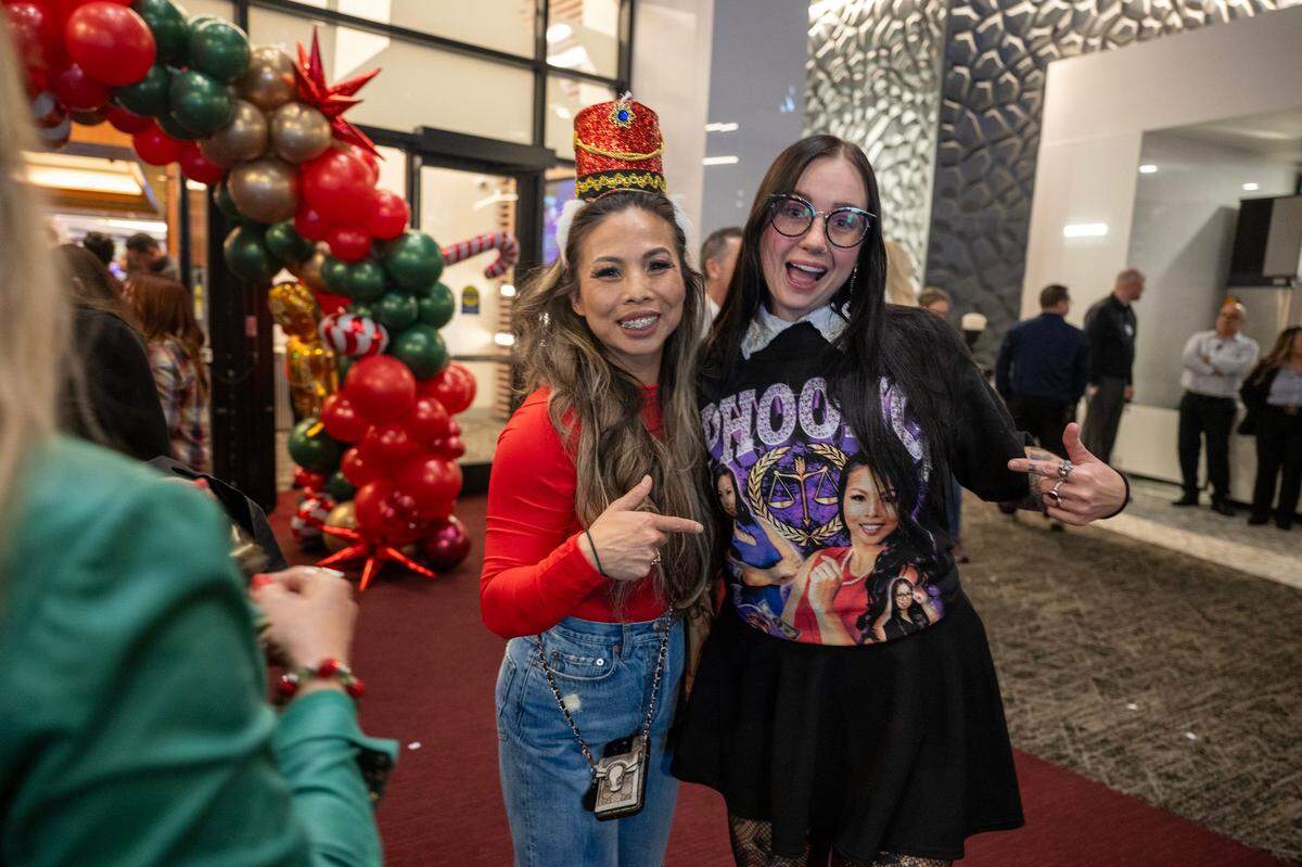 Lindsey McDonald, wearing an Anh Phoong printed shirt, poses for a photo with Phoong at the annual Phoong Law Christmas party earlier this month at The Apex at Red Hawk casino.