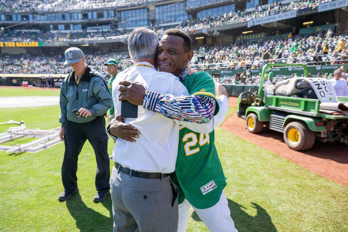 Former Oakland A’s star Ricky Henderson hugs David Renetti, the vice president of stadium operations, before their final game at Oakland-Alameda County Coliseum on Thursday.