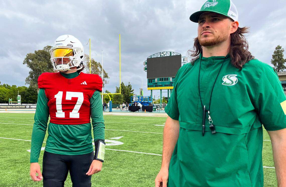 Sacramento State quarterback Carson Conklin talks to assistant coach Kaden Richardson, on Saturday as the team prepares for its spring game. 