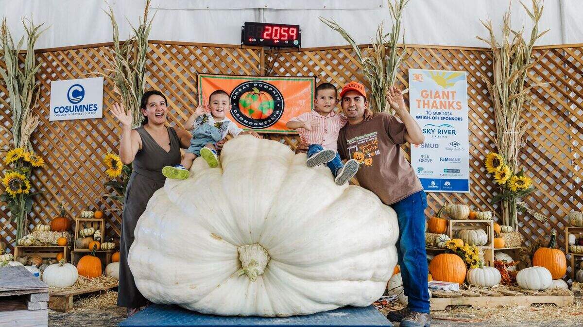 Ruben Frias celebrates alongside his family after winning the Giant Pumpkin Weigh-Off at the Elk Grove Giant Pumpkin Festival on Saturday.