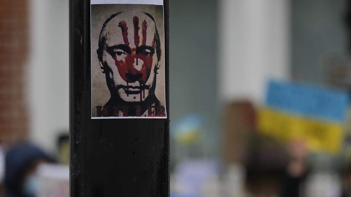 An anti Russian President Putin poster placed on a traffic light column as Pro-Ukraine demonstrators protest against the Russian invasion of Ukraine in front of the Russian Embassy in London, Tuesday, March 1, 2022. Russian shelling pounded civilian targets in Ukraine’s second-largest city Tuesday and a 40-mile convoy of tanks and other vehicles threatened the capital — tactics Ukraine’s embattled president said were designed to force him into concessions in Europe’s largest ground war in generations.