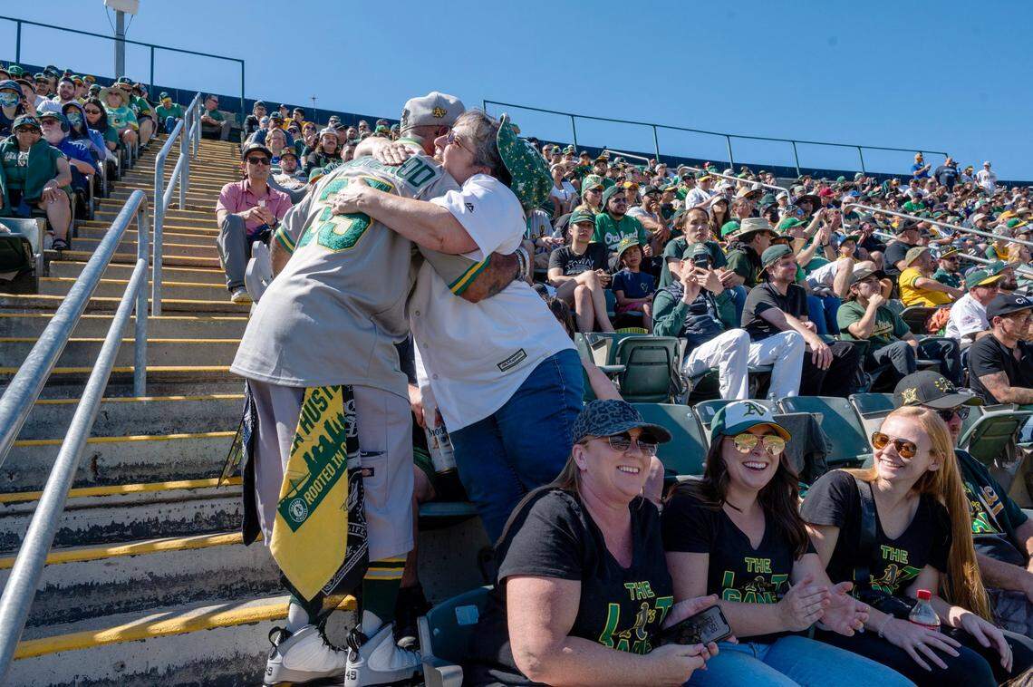 Oakland A’s fans Andrew Rodriquez and Nancy Figueroa hug during the team’s final game at Oakland-Alameda County Coliseum on Thursday.