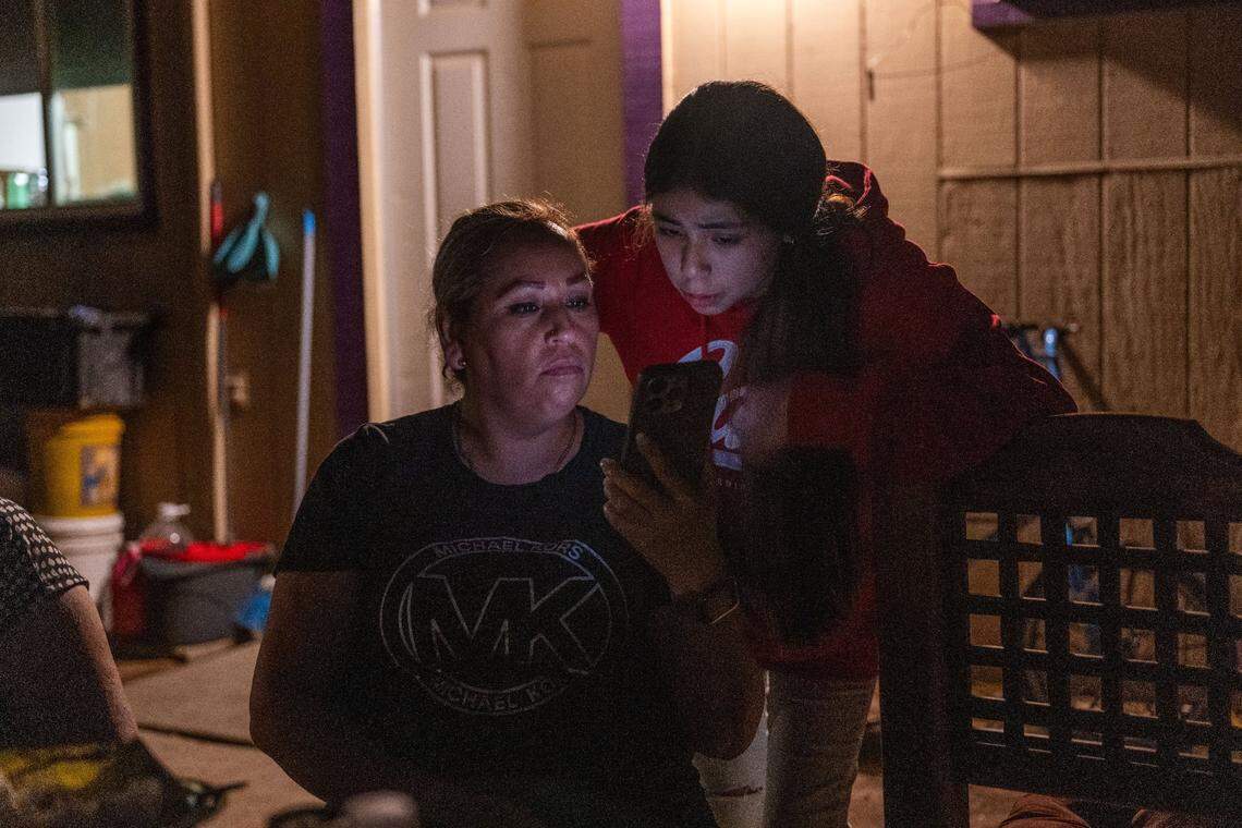 Lorena Perez Guzman looks at a message from school with her daughter Karla Acevedo Perez at the Lodi migrant center in October.