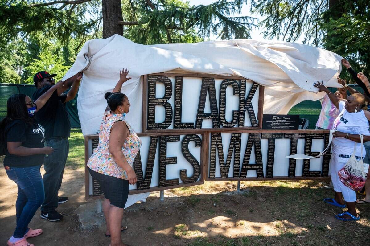 5. Black Lives Matter Sacramento leader Tonya Faison, third from left, helps unveil a new Black Lives Matter monument with family members of Black people killed by police in the Sacramento region, at McClatchy Park in Sacramento’s Oak Park neighborhood on Saturday, May 29, 2021. The monument was created by artist Zach Trowbridge as a re-creation of one that was placed at Curtis Park last year and damaged by vandals. The monument’s placement in McClatchy Park was approved by the Sacramento City Council.