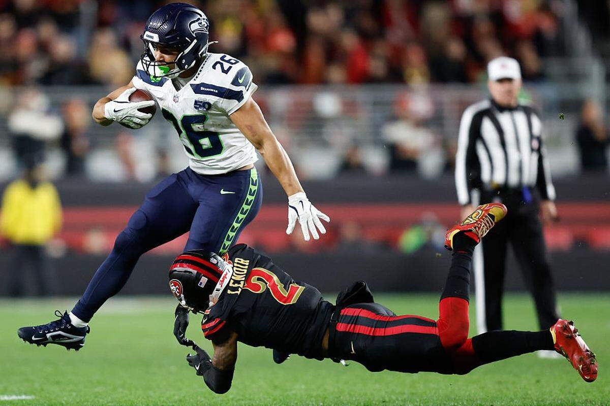 Zach Charbonnet of the Seattle Seahawks runs with the ball against Deommodore Lenoir of the San Francisco 49ers during the third quarter of a game at Levi's Stadium on Saturday, Jan. 3, 2026, in Santa Clara.