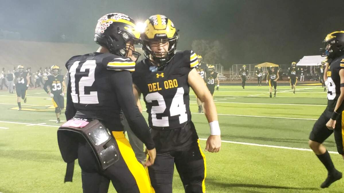 Del Oro High School quarterback Caden Pinnick (12) and linebacker Talan Jewett (24) hype each other up before their 37-23 victory over Laguna Creek on Friday, Nov. 3, 2023, in Loomis.