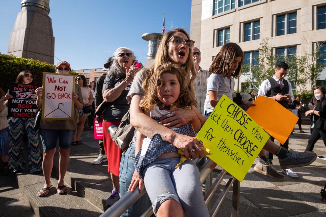 Shauna Goodman, of Sacramento, attends the demonstration with her two children outside the federal courthouse in downtown Sacramento on Tuesday.