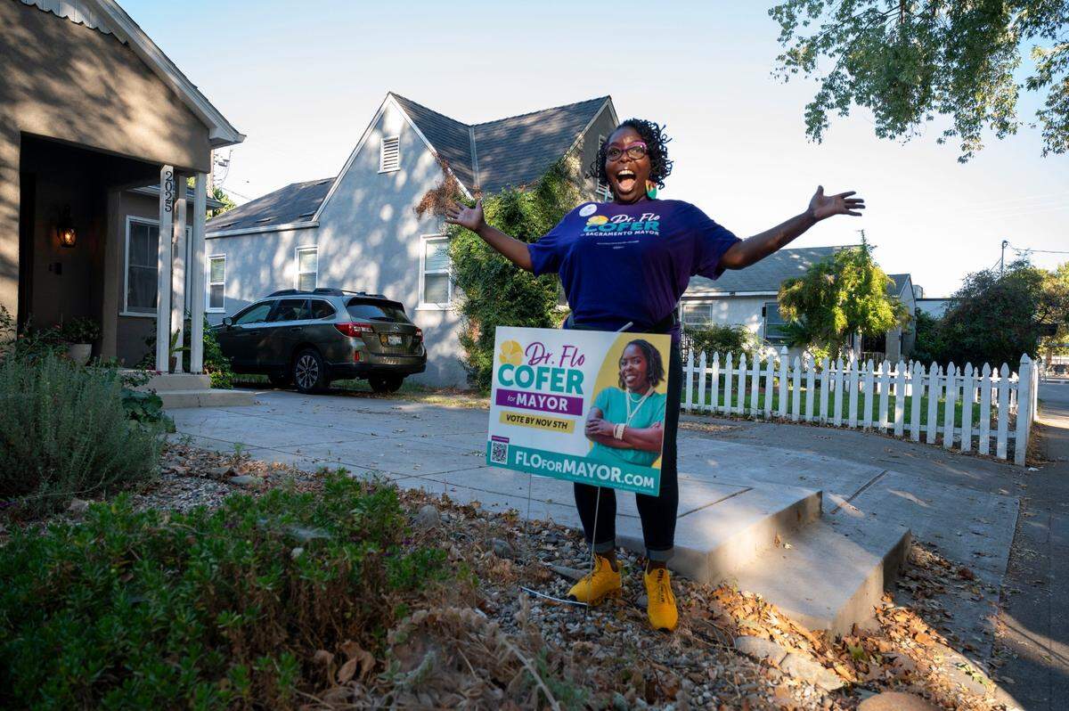 Mayoral candidate Flo Cofer puts up a yard sign Tuesday, Oct. 1, 2024, at the home of Land Park resident Ashley Osterlund home while out canvassing for voter support.