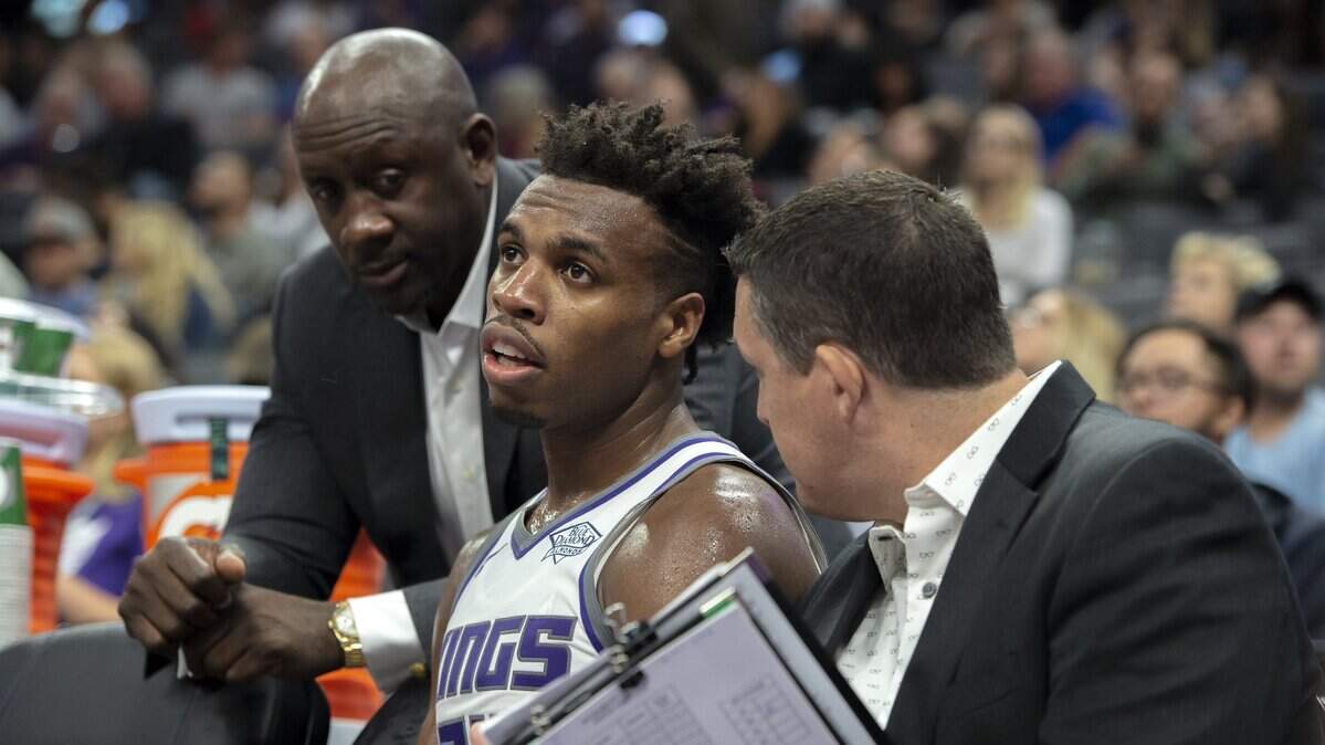 Kings guard Buddy Hield speaks with coaches Bobby Jackson, left, and Jason March during a preseason game against the Utah Jazz on Thursday at Golden 1 Center. Hield was ninth in the NBA in 3-point shooting last season at 43.1 percent, but he was 34th in attempts.