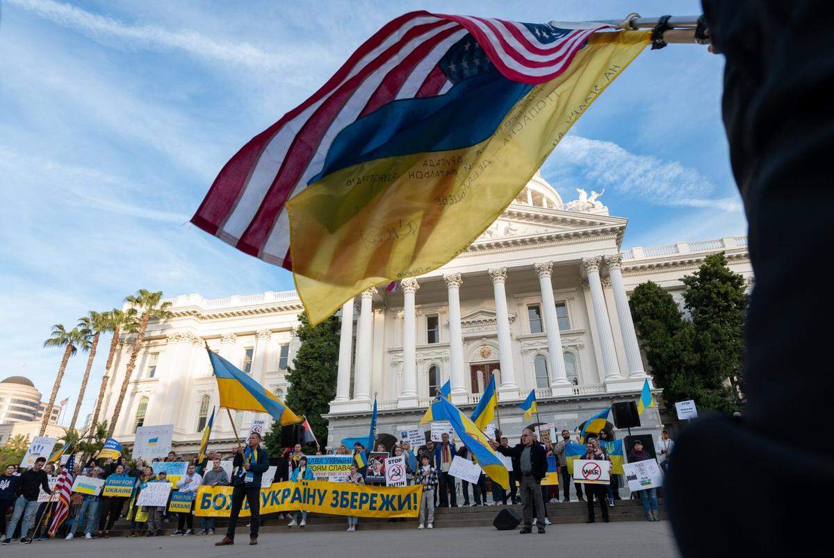 Local Ukrainian community members wave the Ukraine flag during a rally on Thursday at the state Capitol against the Russian invasion of the country.