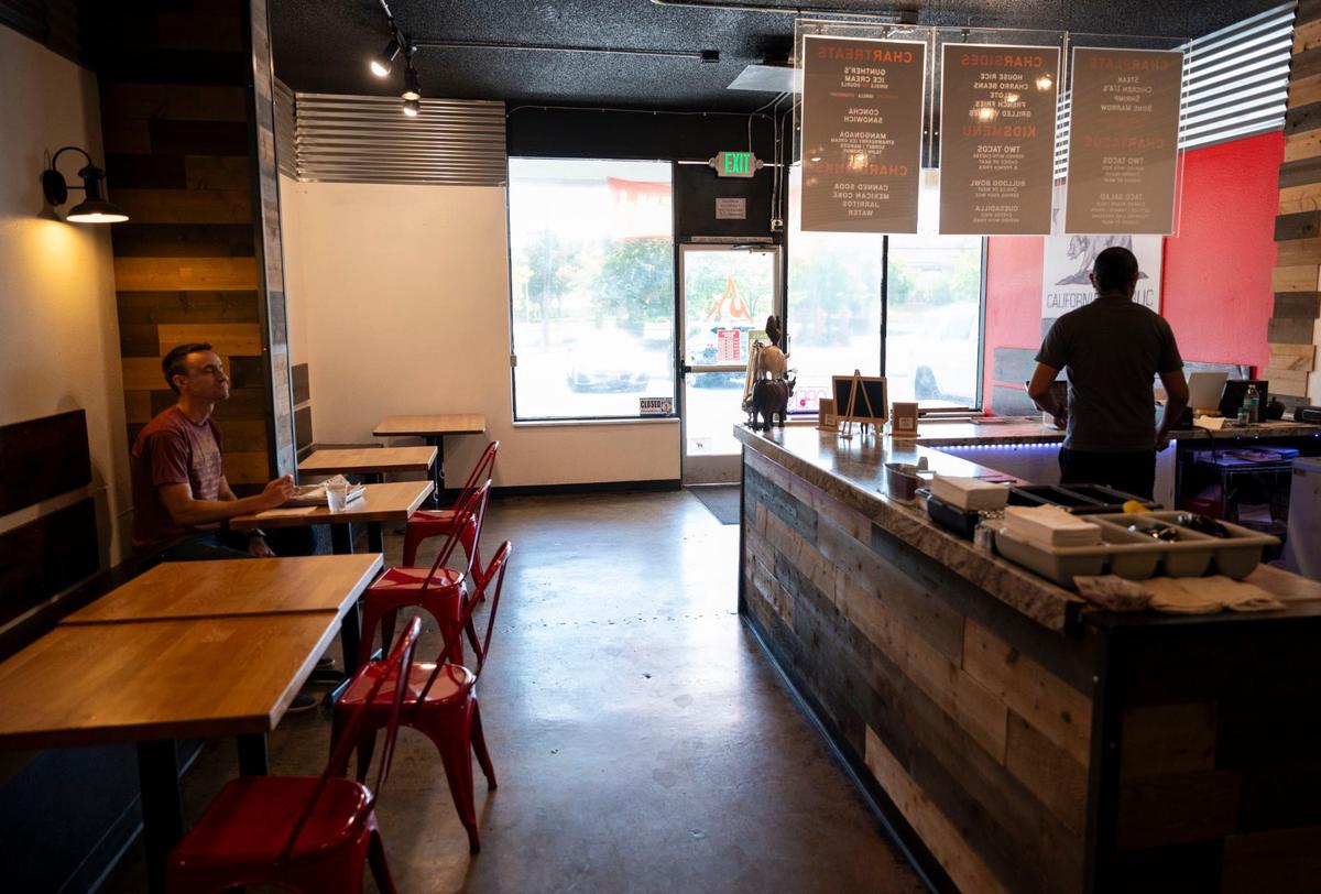 Customer Jason Paula, left, eats lunch at Char Market in Carmichael as co-owner Noah Corsey stands behind the counter on Thursday, Aug. 29, 2024. The restaurant was named the third-best Mexican restaurant in the United States by Yelp, which ranked this year’s top 25 spots.