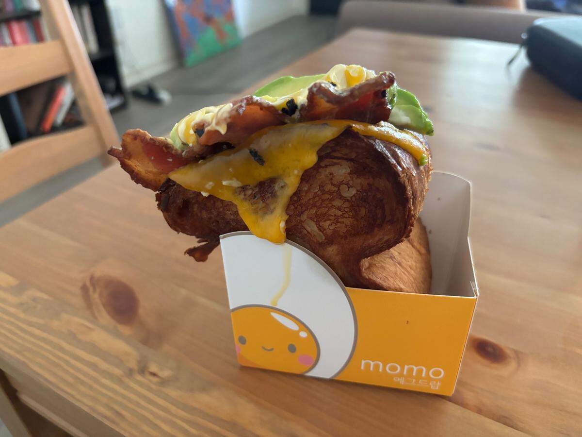 Momo Korean Egg Drop’s Gwangju Bacon sandwich with added avocado. Though the sandwich’s slice of cheddar cheese was not melted when it came out of the kitchen, 30 seconds in the microwave was enough to make it perfectly gooey.