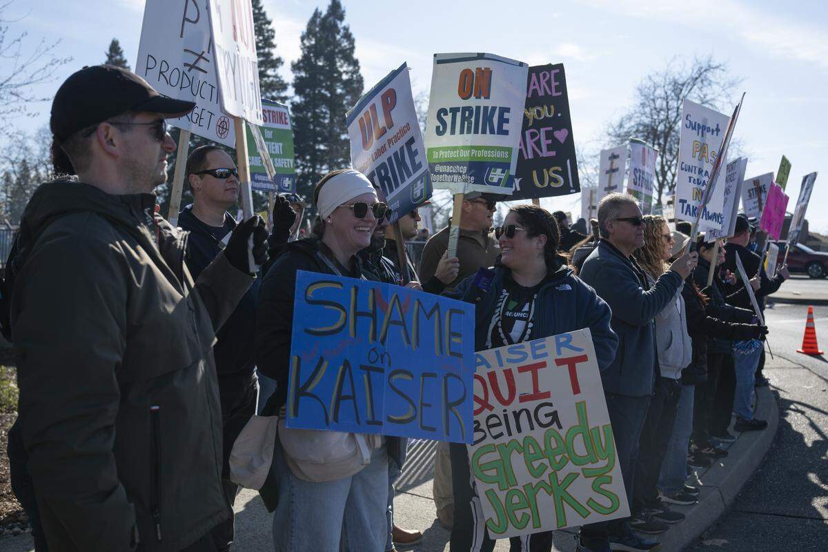 Striking medical workers wave signs outside Kaiser Permanente’s Roseville Medical Center in Roseville on Monday, Jan. 26, 2026.