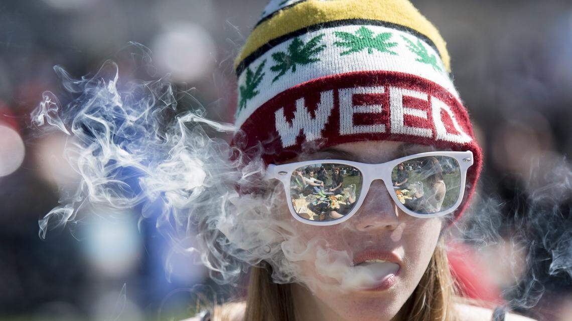 A woman exhales while smoking marijuana during the annual 420 marijuana rally in Ottawa, Canada on April 20, 2016.