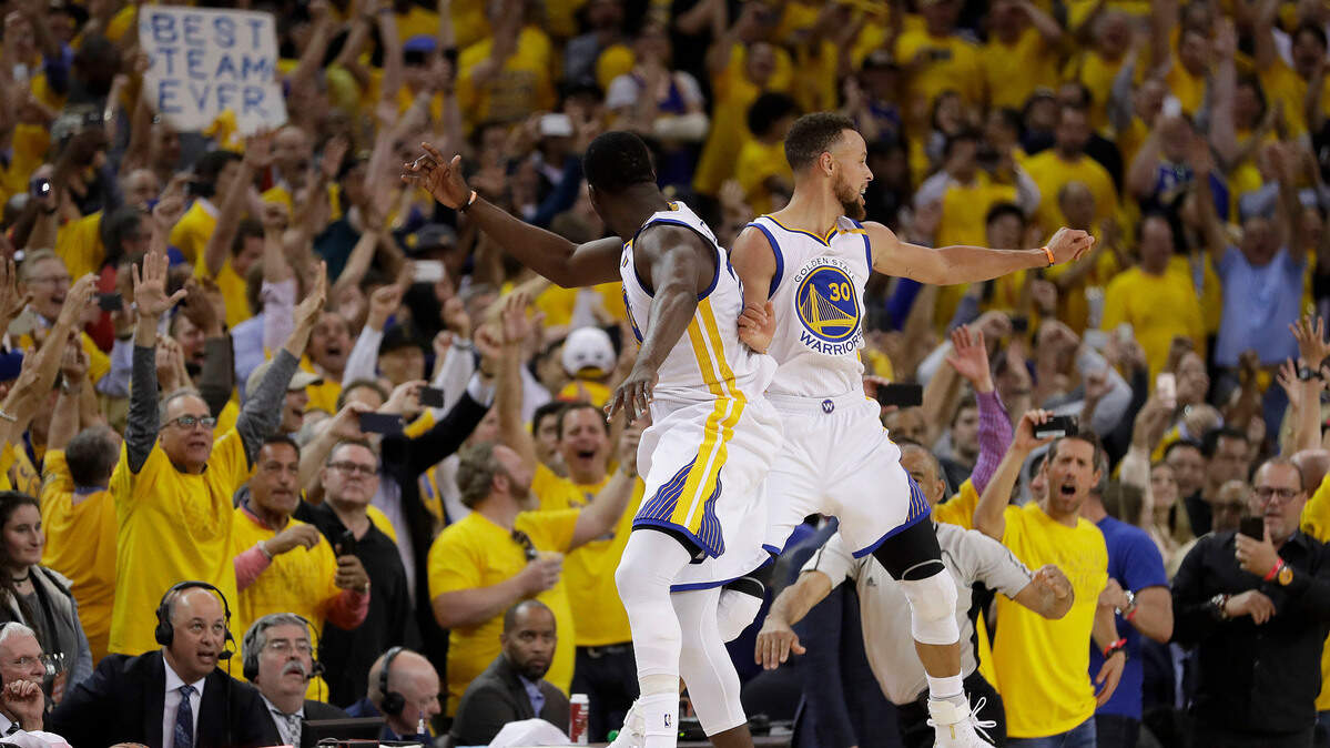 Fans look on as Golden State Warriors forward Draymond Green, left, and guard Stephen Curry celebrate during Game 5 of last year's NBA Finals on June 12, 2017, in Oakland. The Warriors beat the Cleveland Cavaliers 129-120 to clinch the title.