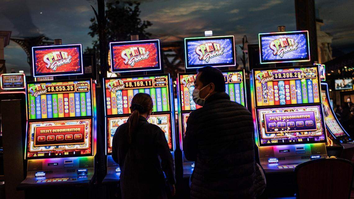 People stand in front of electronic slot machines in a casino in Las Vegas in 2020.