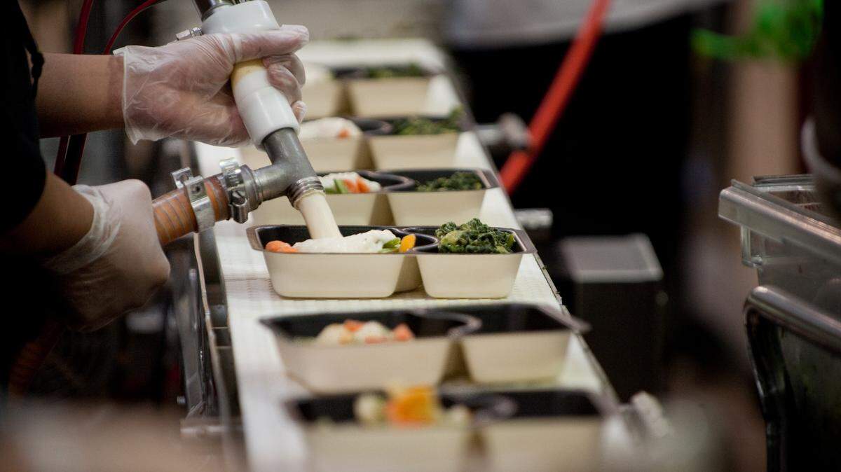 Sacramento State volunteers fill meals trays with ingredients for Meals on Wheels as part of a “working spring break” in 2011.