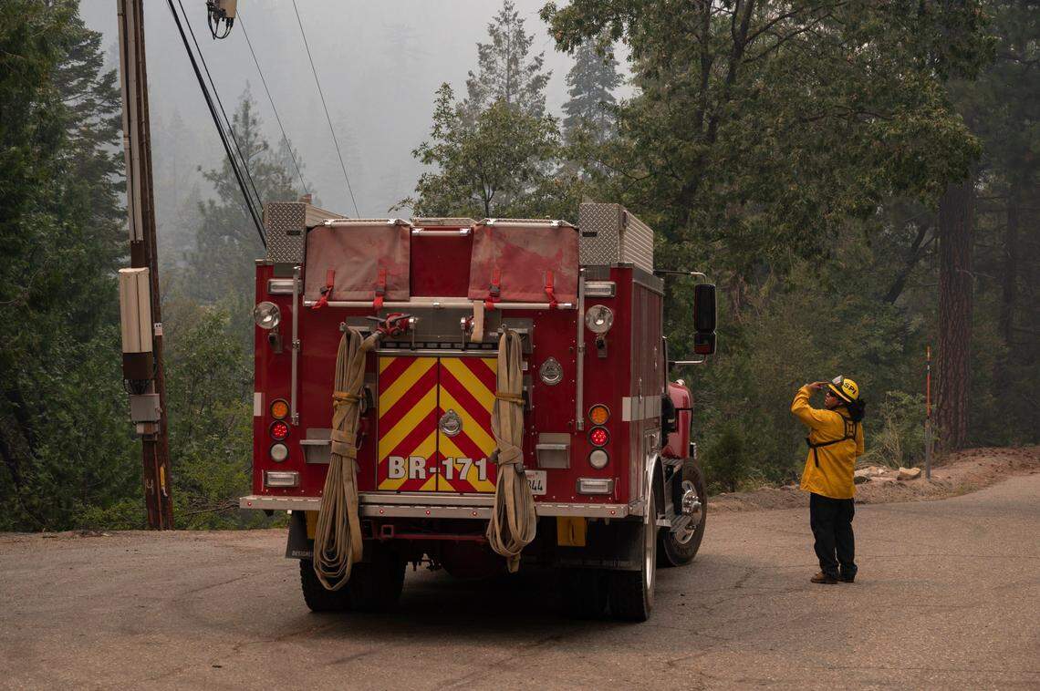Adelaido Campoverde, an engineer from the San Pasqual Fire Department, watches for spot fires from the Caldor Fire from a Highway 50 turnout near Eagle Rock east of Kyburz on Sunday.