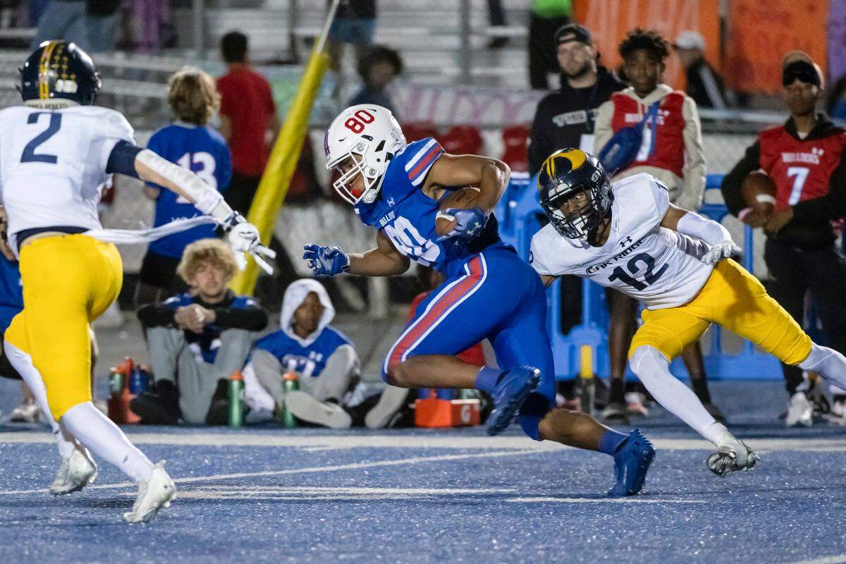 Folsom Bulldogs wide receiver Brian Ray III (80) runs the ball for a first down before being tackled by the Oak Ridge Trojans’ Ryan Hickey (2) and Jasen Womack (10) in September at Folsom High.