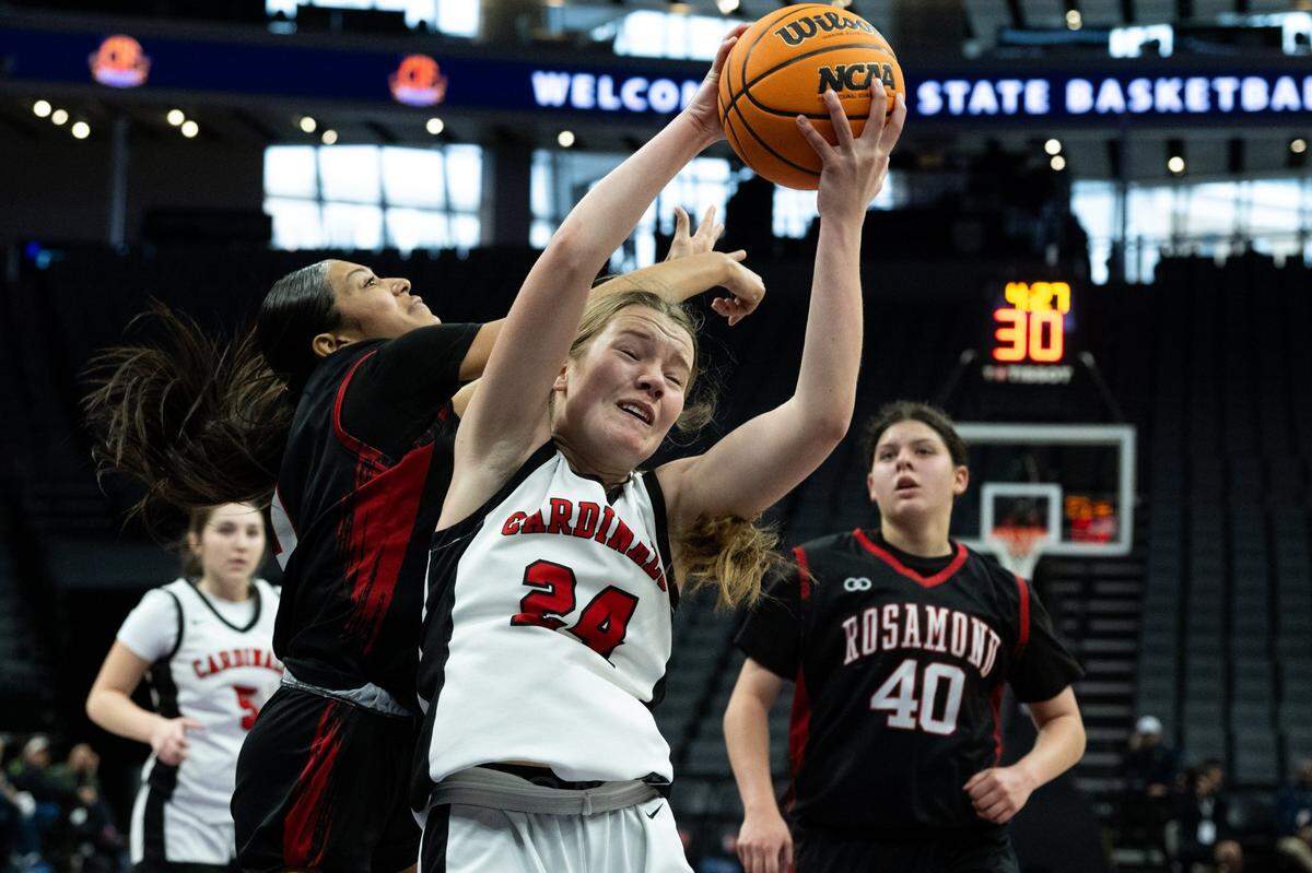 The Woodland Christian Cardinals’ Bailee Broward and the Rosamond Roadrunners’ Abigail Cordoza battle for rebound during the CIF Division V State Championship girls basketball game at Golden 1 Center on Friday.