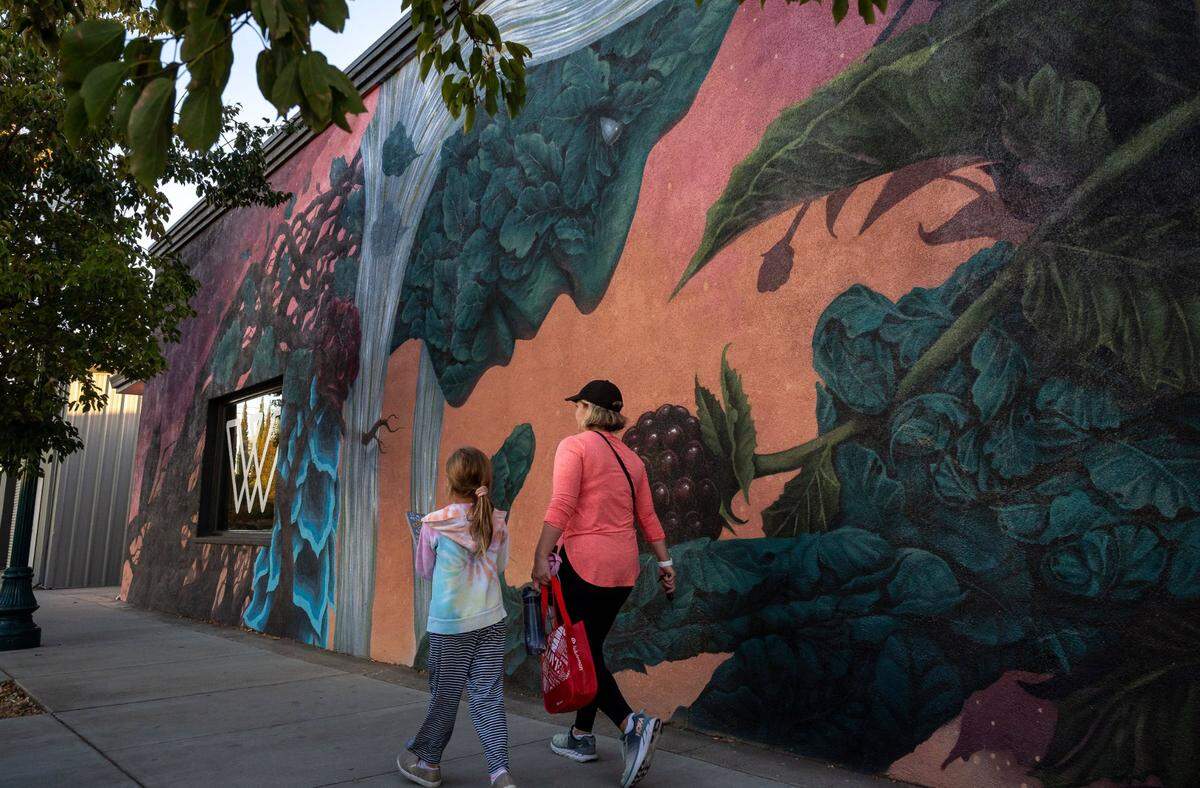 Pamela Kokoszka and her daughter Maddie, 9, of Rocklin, leave a class at Winks Fitness & Wellness Studio and pass by the “Harvest” mural, painted by S.V. Williams and Molly Devlin, at 501 Vernon Street on Oct. 13.