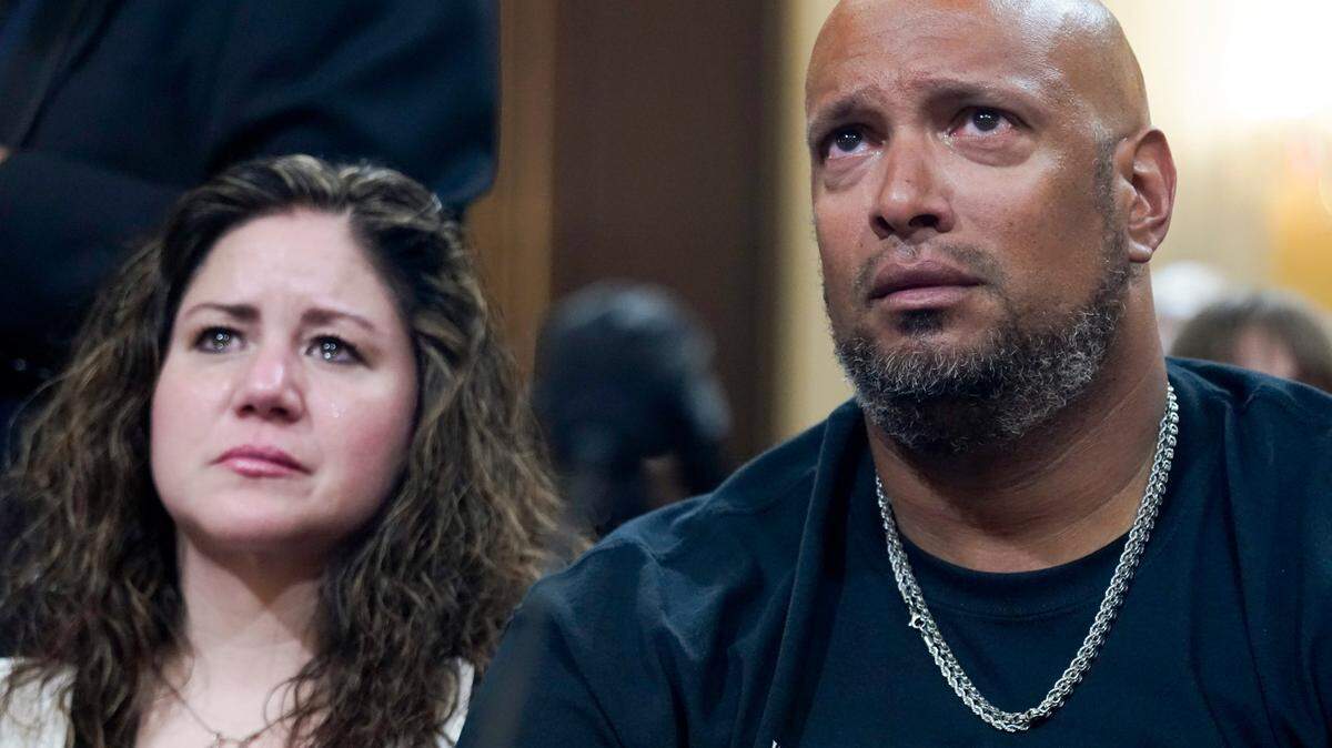 U.S. Capitol Police Sgt. Harry Dunn, right, and Sandra Garza, the long-time partner of fallen Capitol Police Officer Brian Sicknick, left, react as a video of the Jan. 6 attack on the U.S. Capitol is played during a public hearing of the House select committee investigating the attack is held on Capitol Hill, Thursday, June 9, 2022, in Washington.