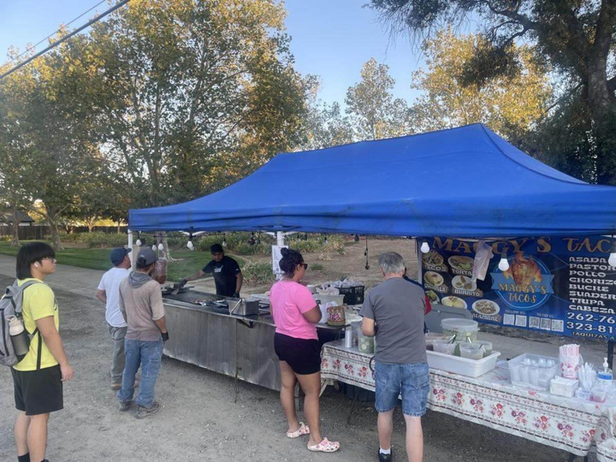Customers patiently wait as they line up at a taco stand around dinnertime in Elk Grove on Wednesday. Stationary pop-up vendors on private property must abide by the same permit and license requirements as sidewalk vendors.