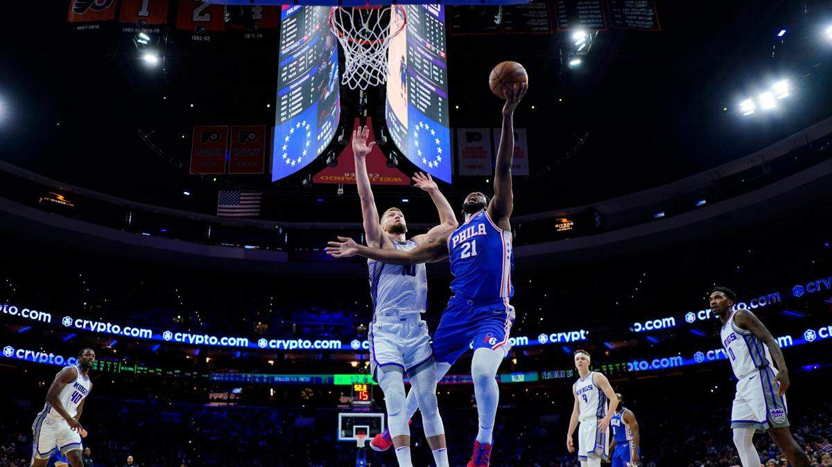 Philadelphia 76ers’ Joel Embiid, right, goes up for a shot against Sacramento Kings’ Domantas Sabonis during the first half of an NBA basketball game, Tuesday, Dec. 13, 2022, in Philadelphia. (AP Photo/Matt Slocum)