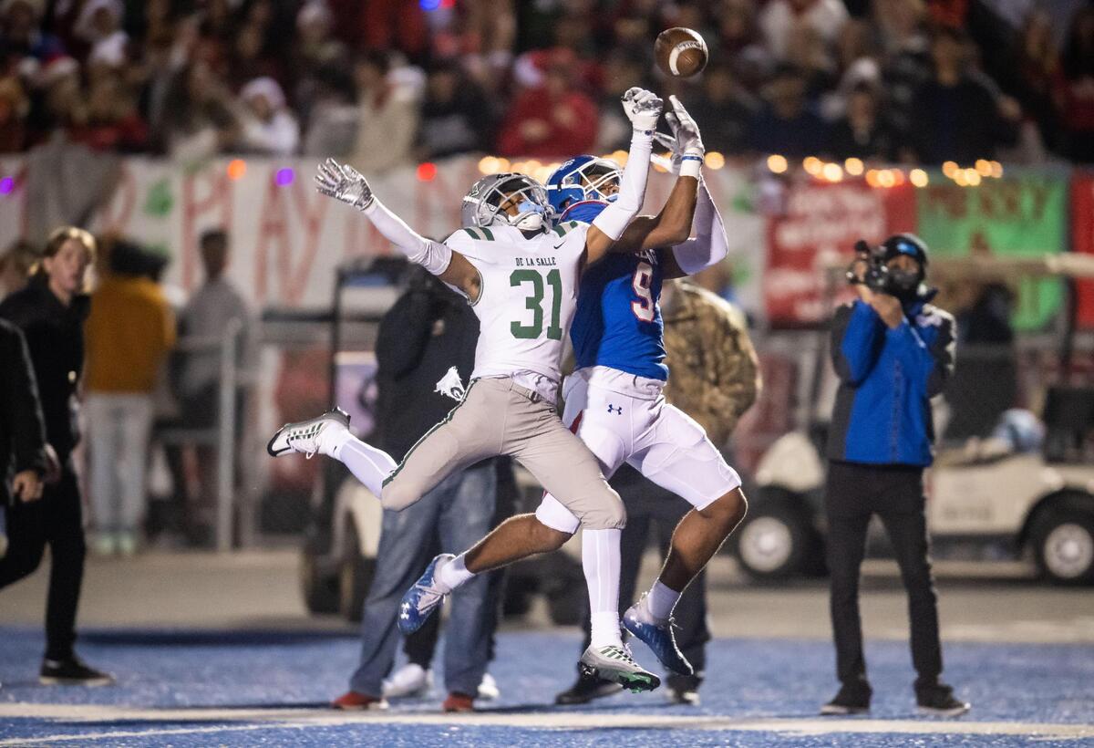 De La Salle (Concord) Spartan defensive back Jaden Jefferson (31), left, tips the ball to prevent Folsom Bulldog wide receiver D.J. Brown (9) from a reception in scoring territory during the second quarter of the CIF Northern California Regional Championship football game Friday at Folsom High School.