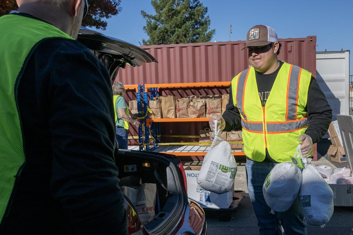 Gio Segura helps distribute food with other volunteers at Joey’s Food Locker, a program run by the Natomas Unified School District, on Friday in Sacramento. The program is set to distribute Thanksgiving meals to more than 1,000 families.