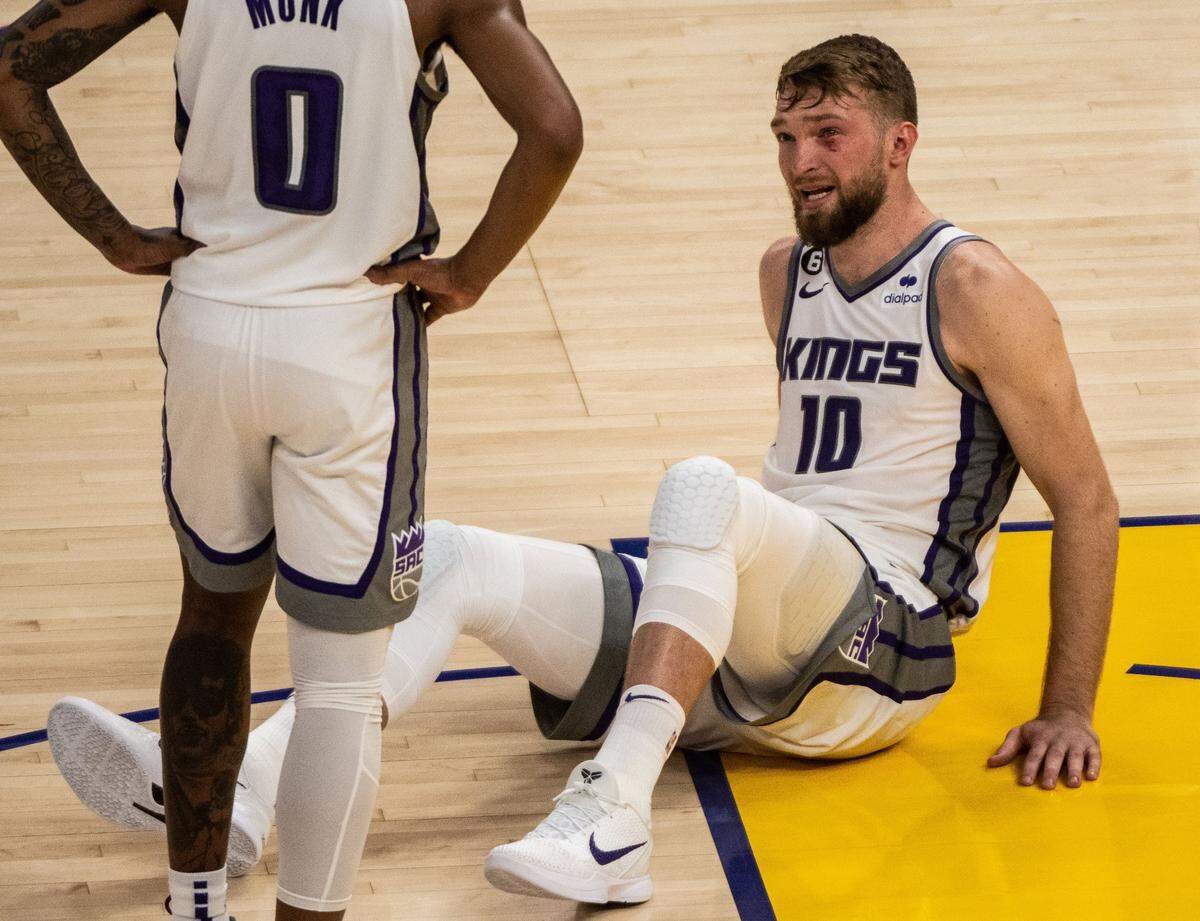 Sacramento Kings center Domantas Sabonis (10) looks at guard Malik Monk (0) after he was elbowed in the face by Golden State’s Kevon Looney during a jump ball during Game 6 of the first-round NBA playoff series at Chase Center on Friday, April 28, 2023.