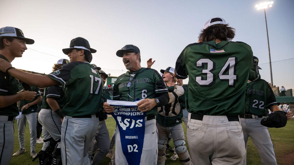 Granite Bay Grizzlies head coach Pat Esposito, center, holds the team’s Sac-Joaquin Section Division II high school baseball championship banner after defeating the Rio Americano Raiders last year at Sacramento City College.
