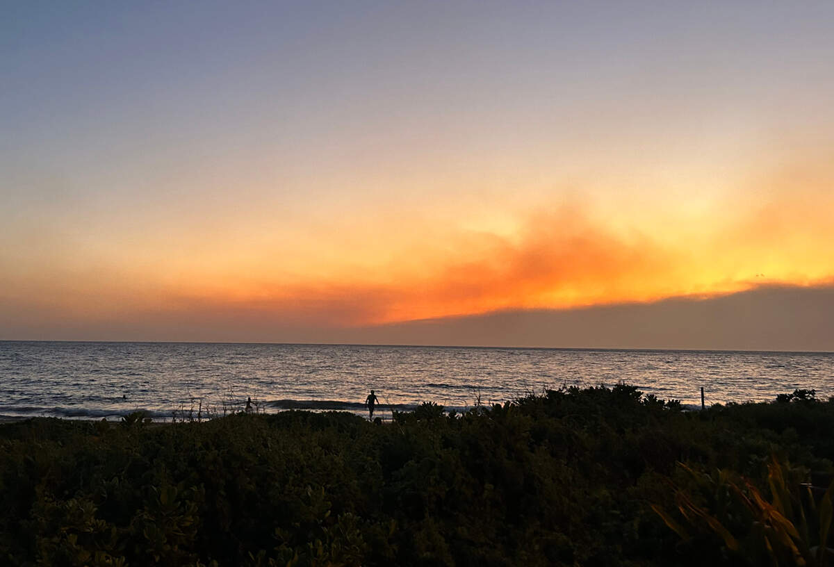 Smoke pools in the air from fires burning on Maui as the sun sets in Kihei on Tuesday.