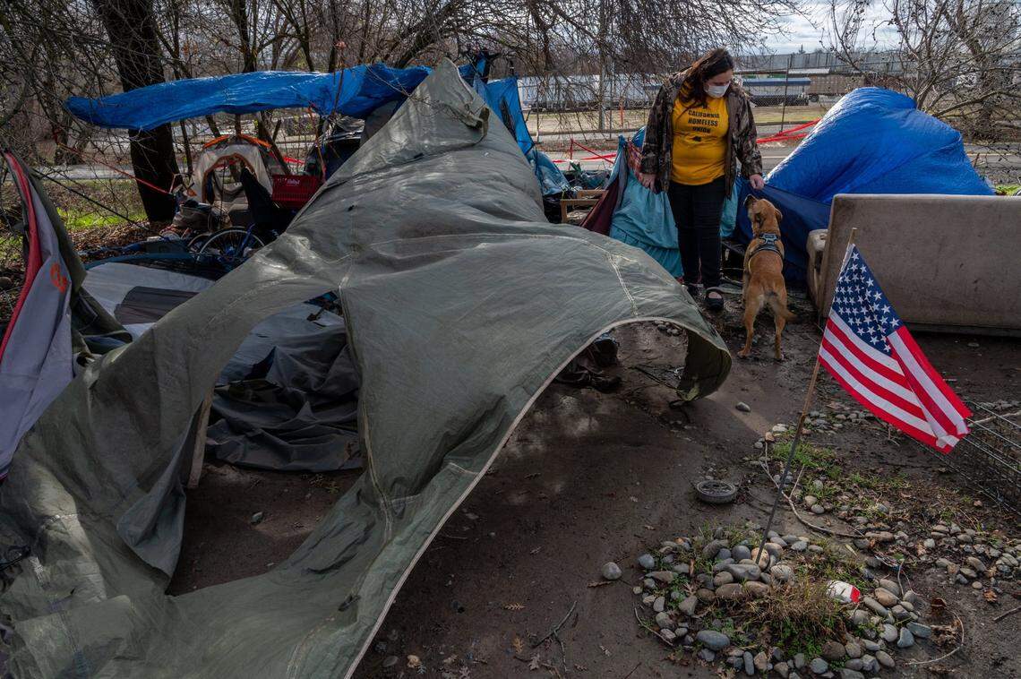 Crystal Sanchez with Sacramento Homeless Union checks on a homeless encampment near Basler and north 18th streets in Sacramento on Wednesday, Jan. 27, 2021, where wind and fallen branches damaged tents.