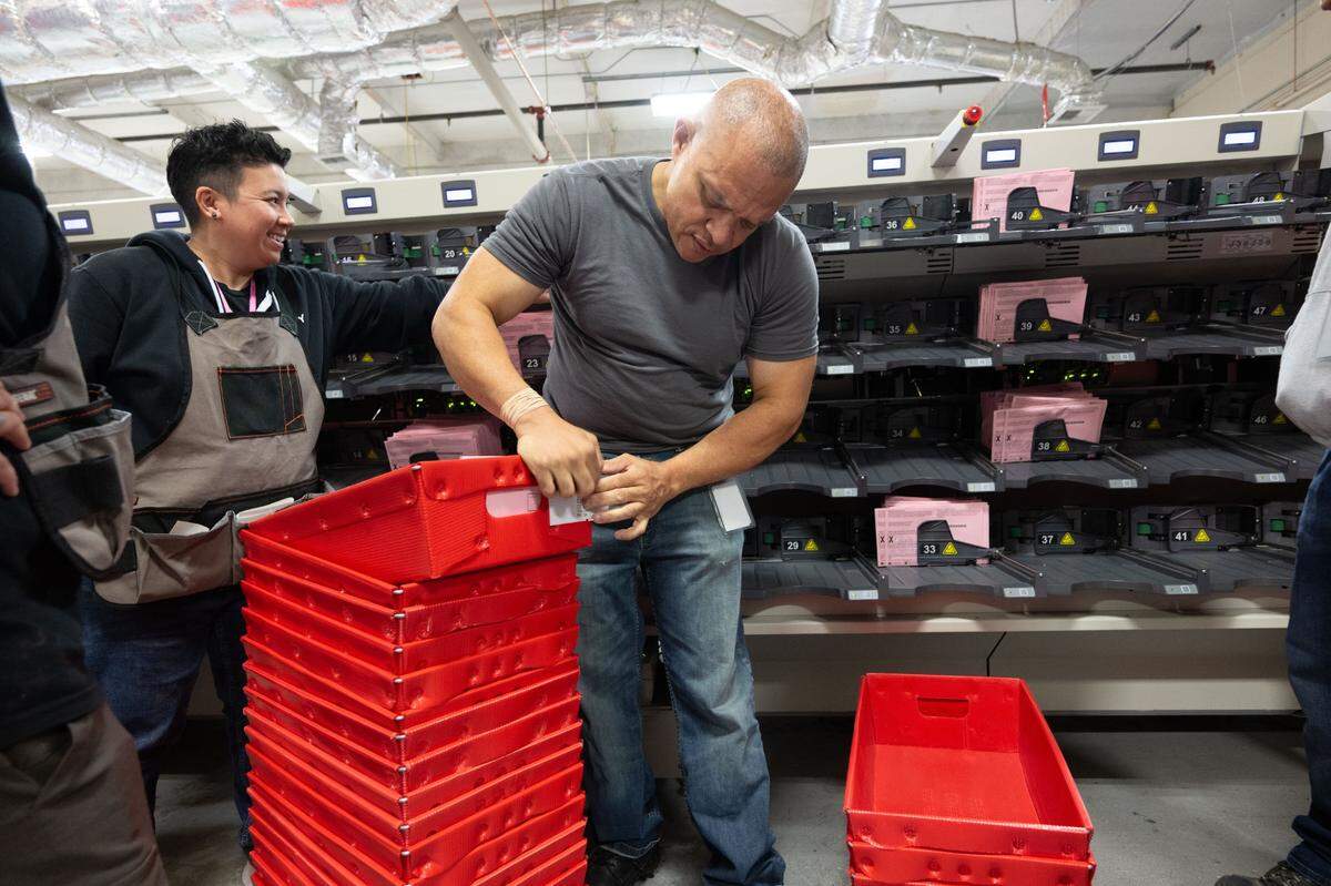 Sacramento County Voter Registration and Elections office workers place ballots into a box after they were sorted into the their districts on Tuesday, Nov. 5, 2024.
