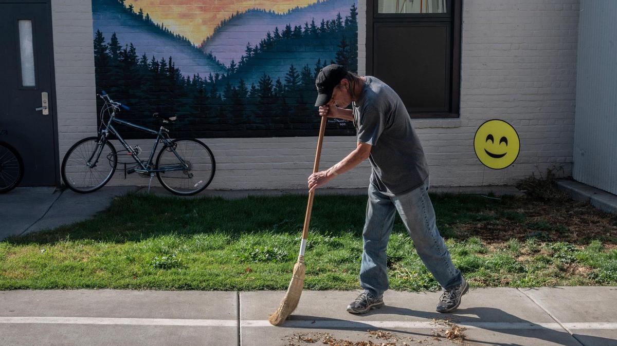 A resident helps clean the sidewalk in the shared courtyard at The Gathering Inn homeless shelter in Auburn on Friday, Oct. 30, 2020. Nick Golling, the director of the mid-Placer Emergency housing, said because it’s Fall and getting colder outside, he expects the numbers of residents to increase.
