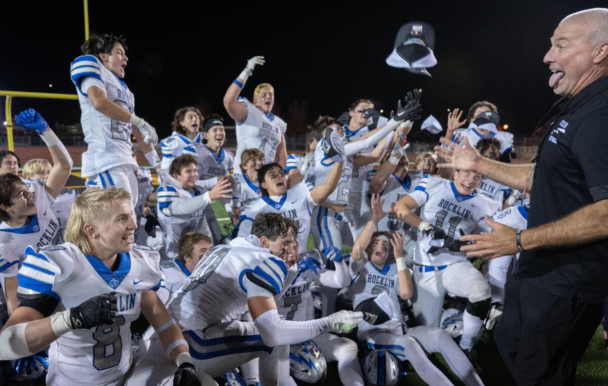 Rocklin High Thunder coach Jason Adams throws hats to his players after they won the CIF Sac-Joaquin Section Division II football championship game against the St. Mary’s Rams of Stockton on Saturday at Hughes Stadium.
