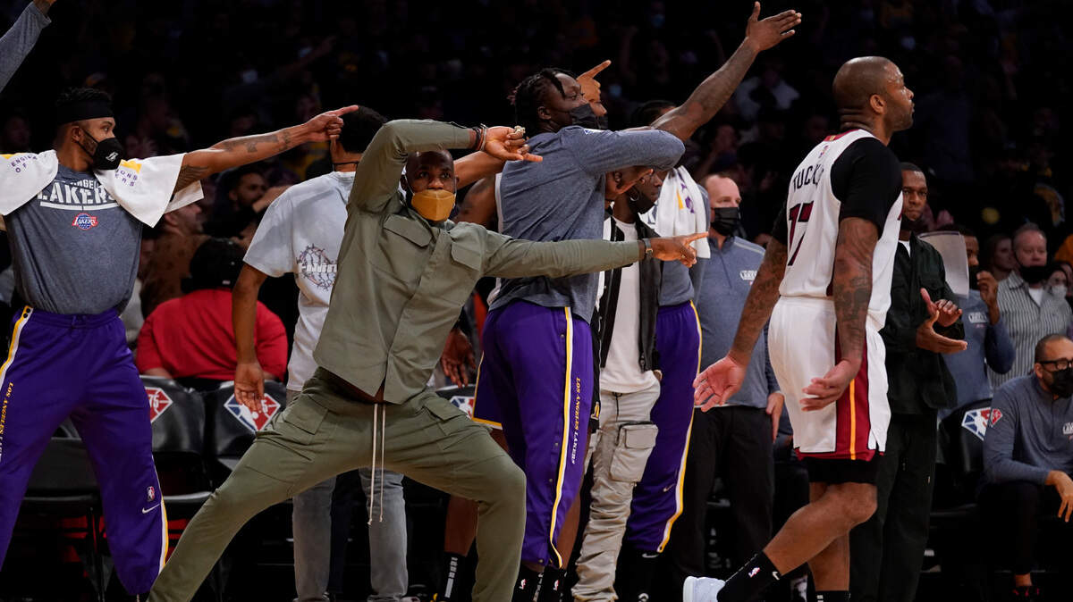 Los Angeles Lakers’ LeBron James, center, and other players signal a turnover as Miami Heat forward P.J. Tucker (17) walks away during overtime of an NBA basketball game in Los Angeles, Wednesday, Nov. 10, 2021. The Lakers won 120-117 in overtime. (AP Photo/Ashley Landis)
