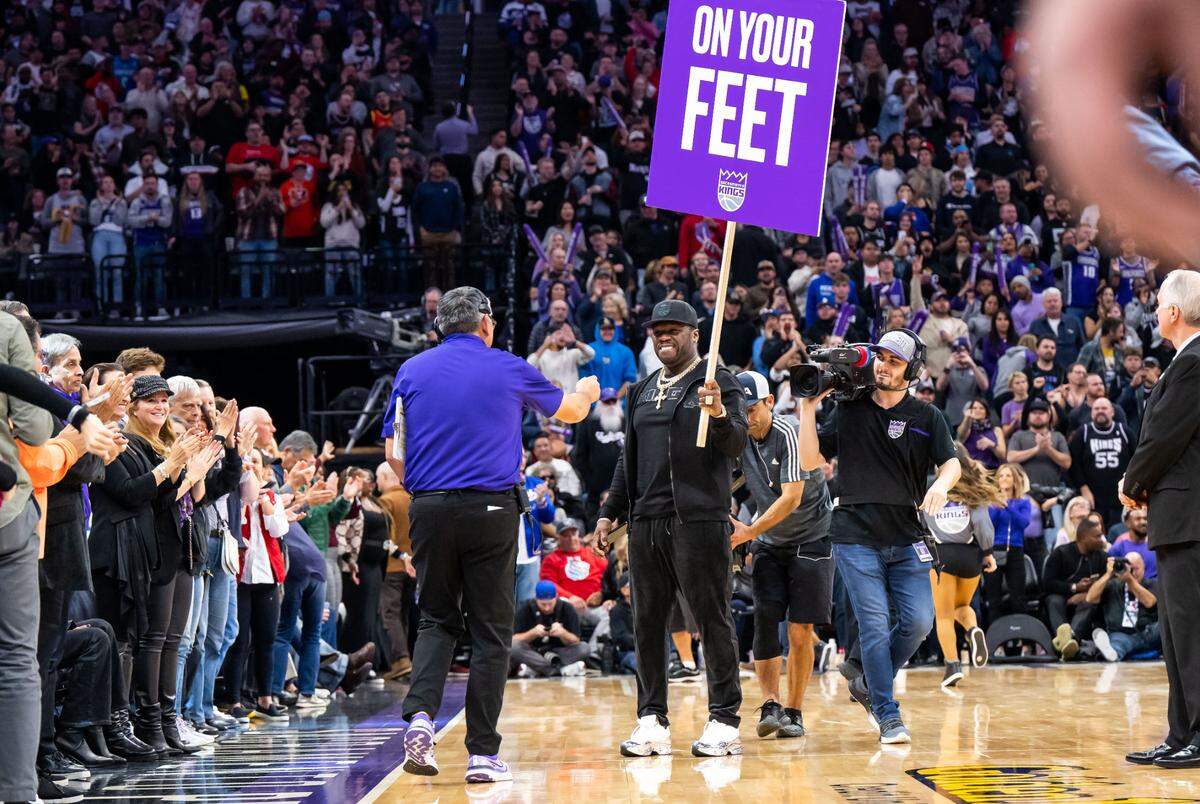 Rapper, businessman and actor 50 Cent (Curtis Jackson) motivates the home crowd with a sign between quarters as the Sacramento Kings host the Indiana Pacers at the NBA basketball game Wednesday, Nov. 30, 2022, at Golden 1 Center in Sacramento.