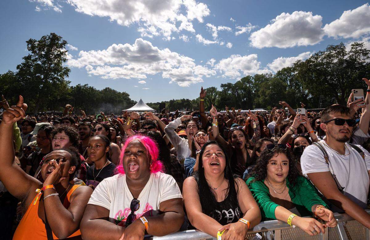 Sporting pink hair and in the from row, Antioch resident Ari Weinert, left, cheers and sings along with friends and fans while rapper Buddy performs on the first day of the Sol Blume music festival at Sacramento’s Discovery Park on Saturday.