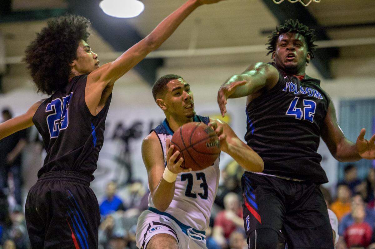 Sheldon Huskies center Chris Wriedt (23) fakes right before going left to score between Folsom’s Deshawn Lynch, right, and Mason Forbes in a playoff game on Feb. 28.