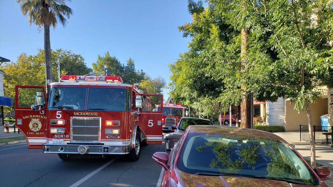 Sacramento fire trucks sit on 21st Street as they respond to a fire at Localis on Tuesday morning.