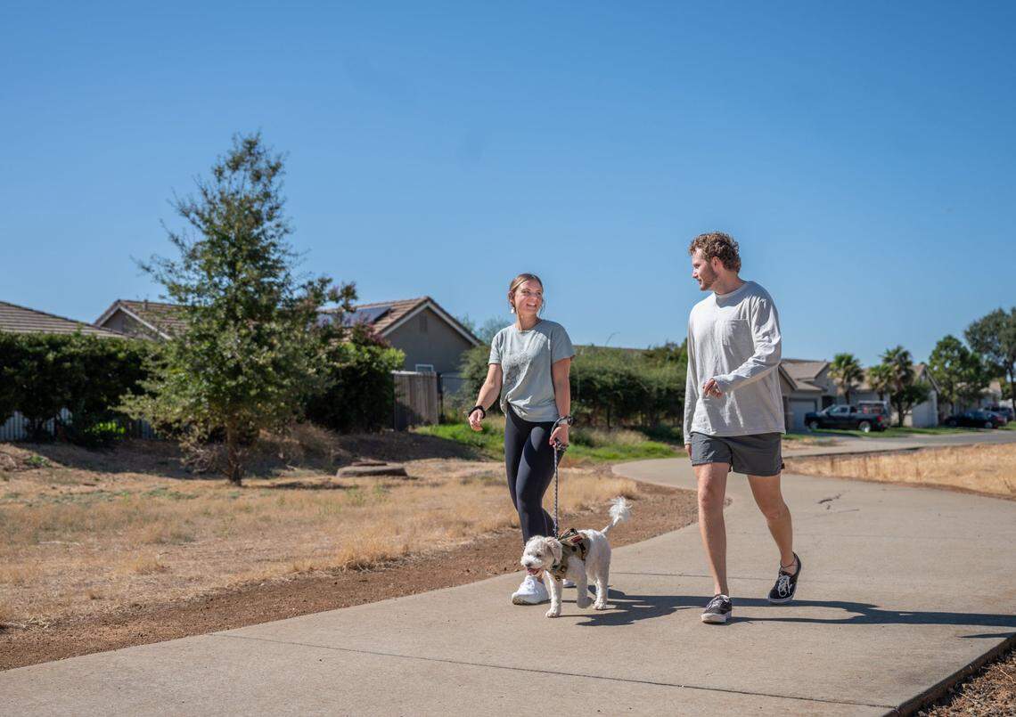 Olivia and Tanner Keller walk their dog Rory near their home in Lincoln on Tuesday, Oct. 3, 2023.