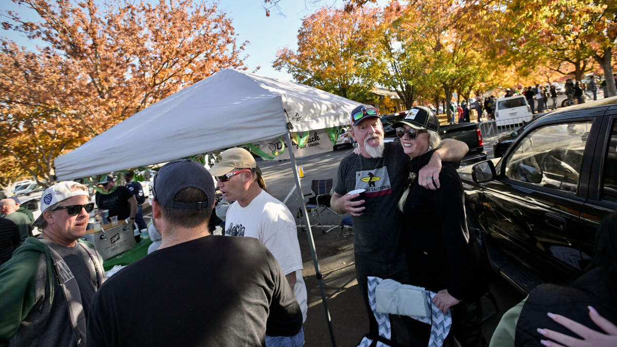 Sukhy, right, and Chris Haney, of Dad’s Kitchen in Sacramento, celebrate Chris’ birthday at their tailgate party as they prepare to watch Sacramento State host UC Davis in the Causeway Classic on Saturday, Nov. 19, 2022, at Hornet Stadium. “Lots of alumni here,” Sukhy said of the staff and friends gathered at their spot in the parking lot.