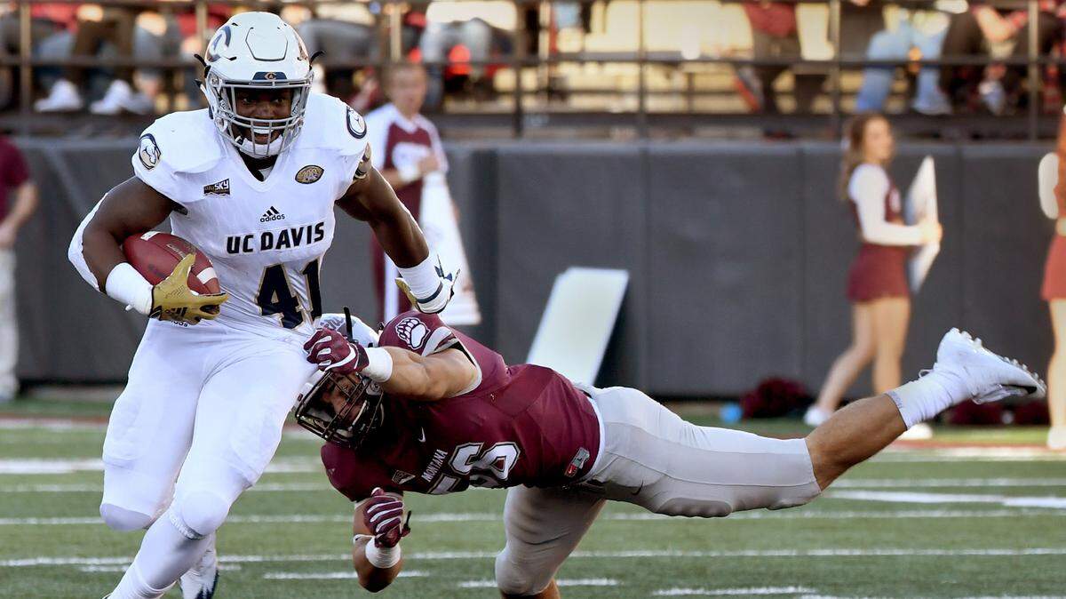 UC Davis running back Tehran Thomas runs past Montana linebacker Marcus Weinel during Saturday’s 49-21 victory in Missoula, Mont.