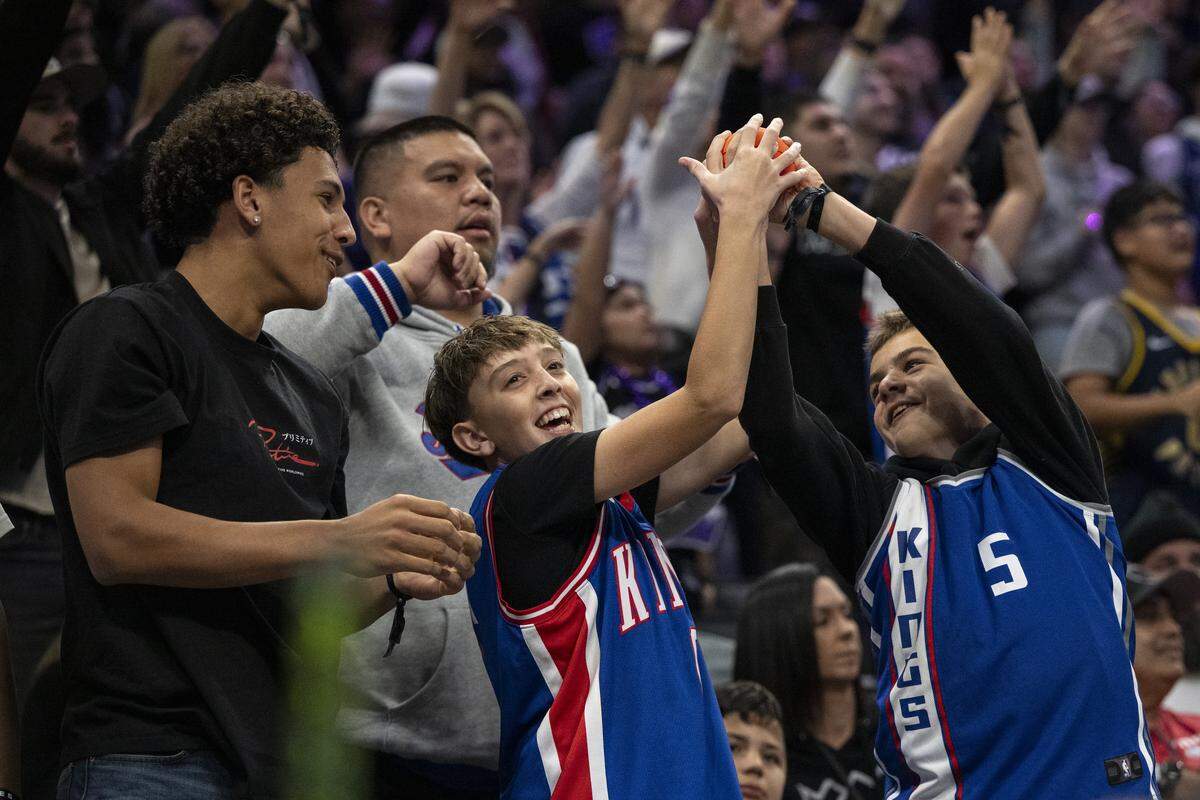 Sacramento Kings fans catch toy basketballs during a game at Golden 1 Center in Sacramento on Sunday, Nov. 9, 2025.