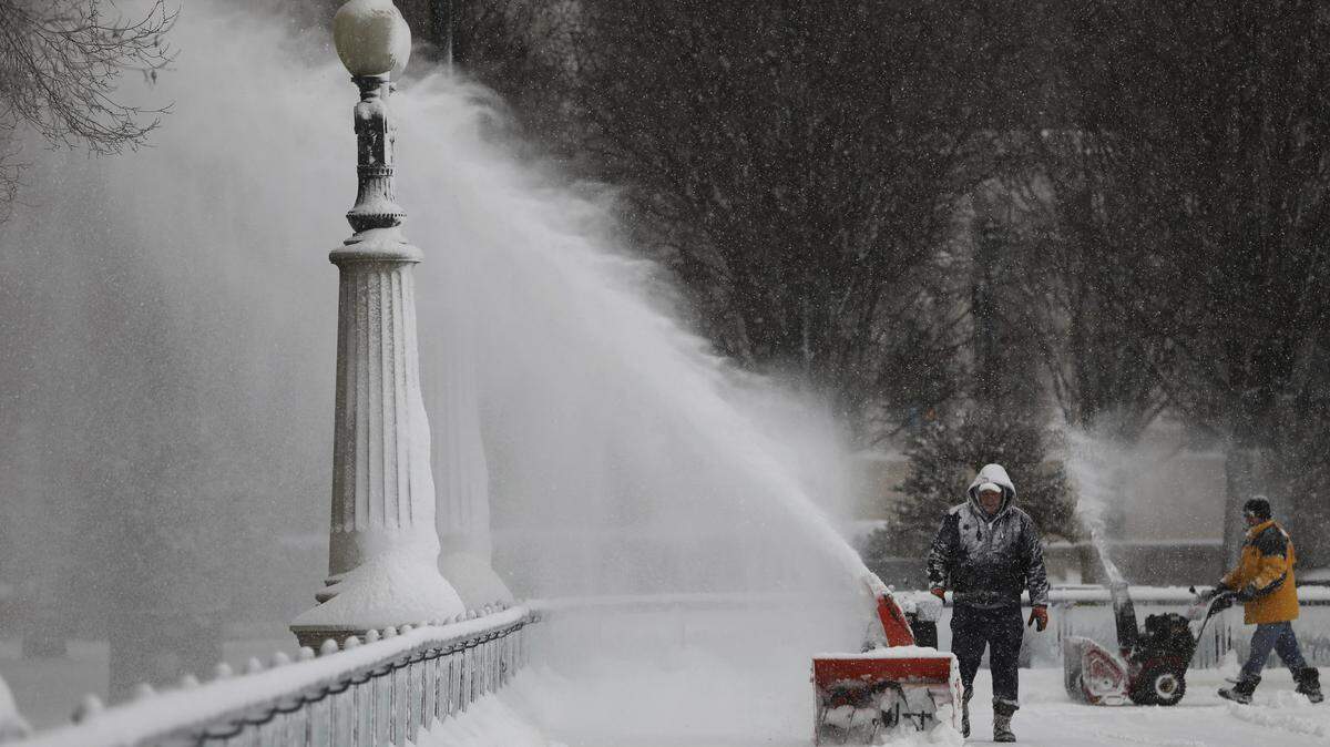 A worker clears snow inside the skating rink in Millennium Park, after a snow storm in Chicago on Saturday. A snow fort collapse on Sunday outside a suburban Chicago church killed a 12-year-old girl.