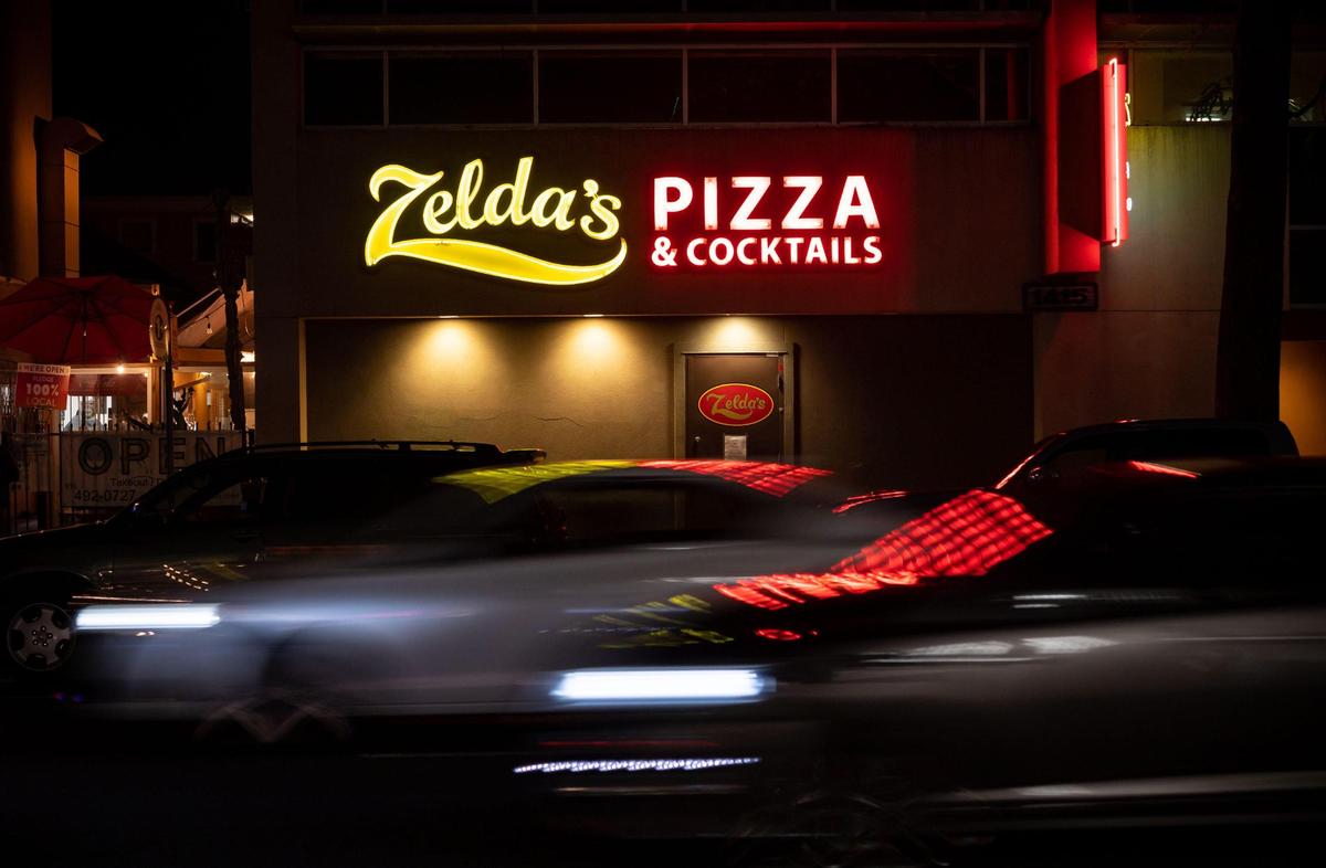 The front door is locked but side door is open for picking up food at Zelda’s Original Gourmet Pizza, known for their Chicago-style deep dish pizza for over 40 years, seen past 21st Street evening traffic Tuesday, Dec. 22, 2020, in midtown Sacramento.