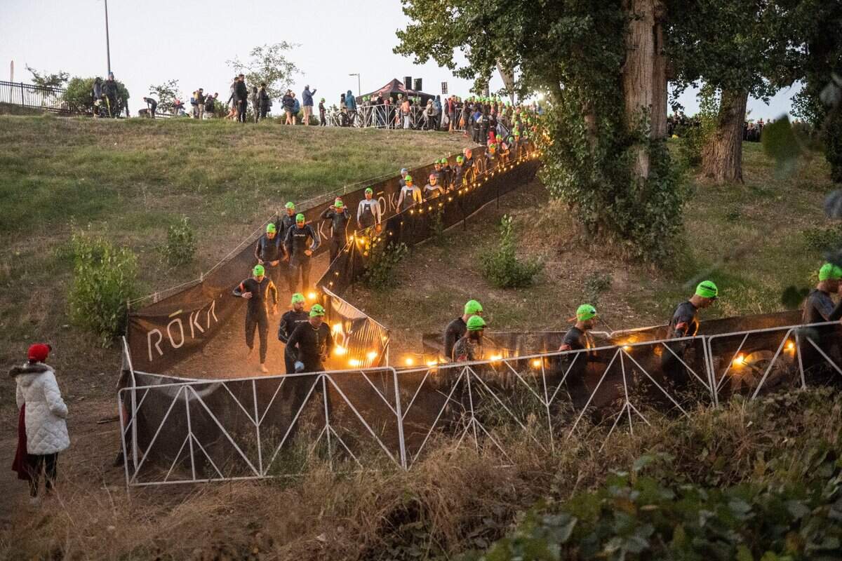 Participants of the Ironman California triathlon make their way to the American River for the swim portion of the competition in Sacramento on Sunday, Oct. 23, 2022.
